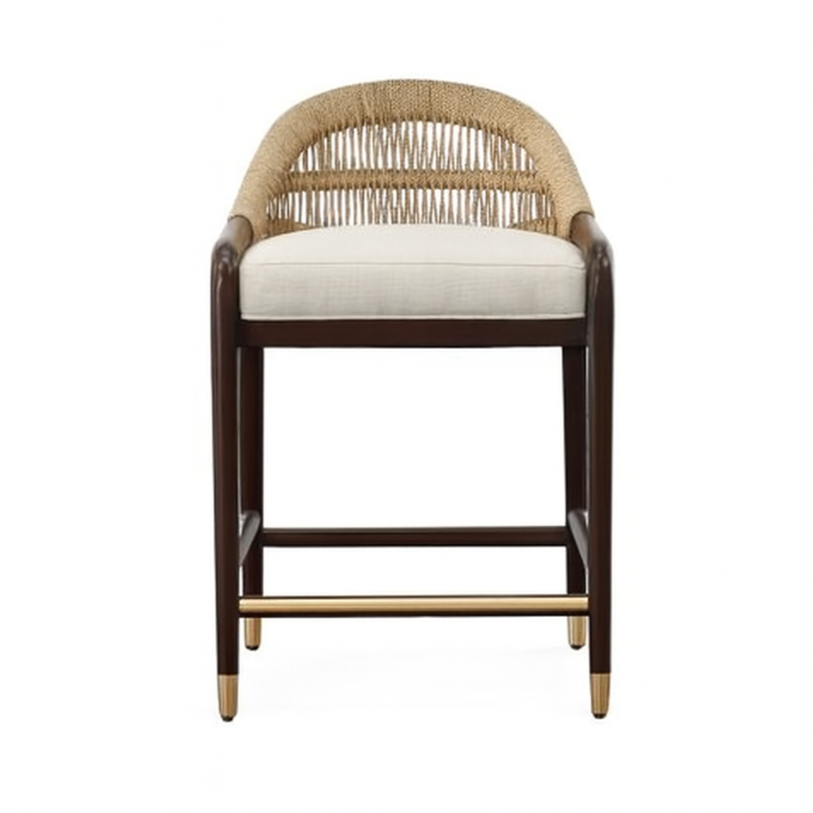 Front view of a coastal-style teak counter stool with woven rope back, neutral beige upholstered seat, dark stained teak frame, and brass footrest and leg caps.