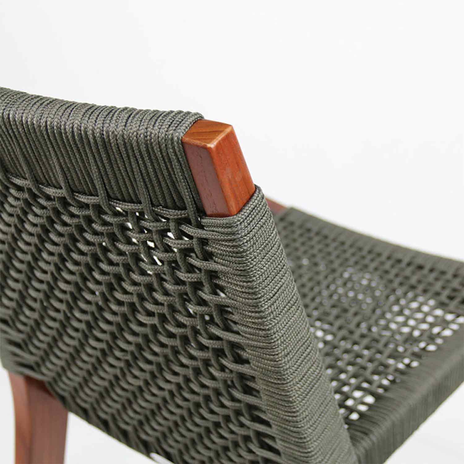 Close-up of an armless teak outdoor bar stool showing the teak frame corner and tightly woven gray rope seat and back, highlighting the coastal-contemporary woven detail.