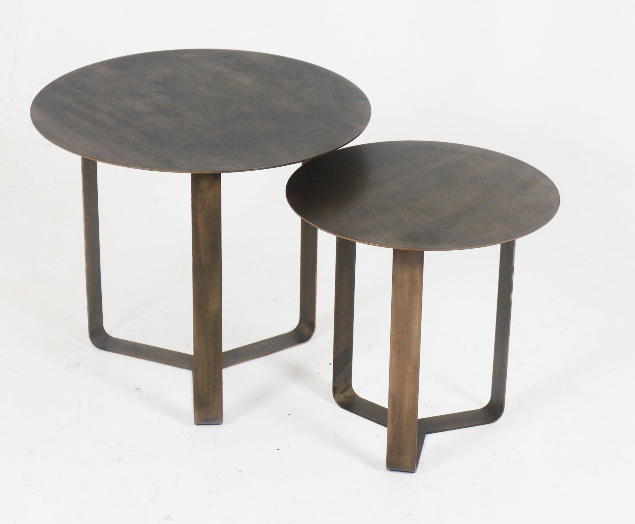 Pair of modern bronze metal side tables with thin round tops and U-shaped legs, one larger and one smaller, photographed on a white background.
