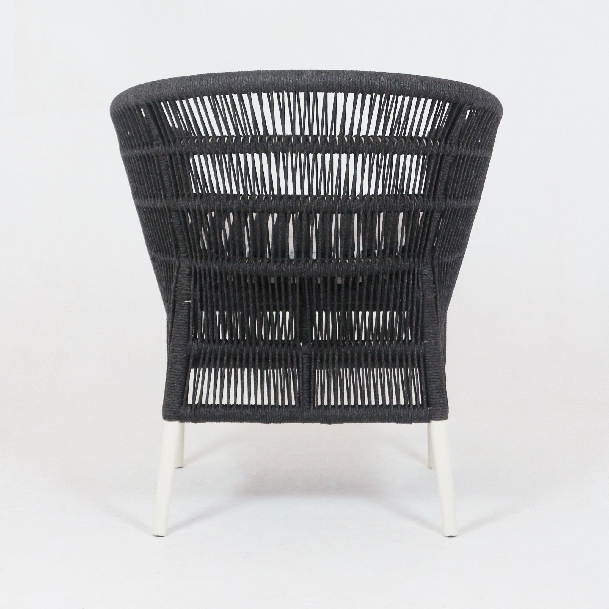 Rear view of a black woven rope outdoor armchair showing flared open-weave back and white metal legs, coastal-style patio seating with vertical and horizontal rope pattern.