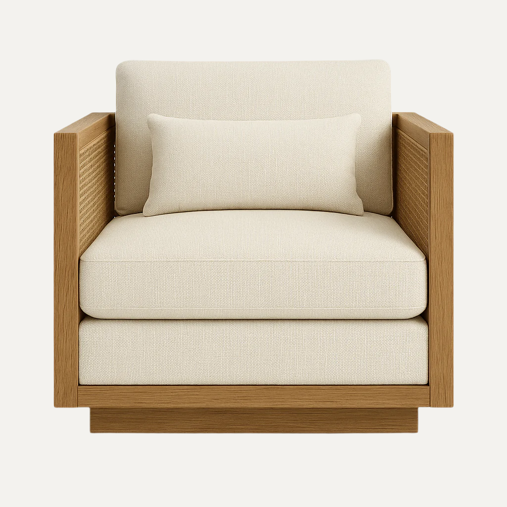 Front view of a coastal-style lounge chair with a natural teak frame, woven cane arm panels and thick cream fabric seat and back cushions with a matching lumbar pillow.