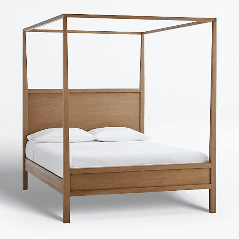 Minimalist mid‑century modern four‑poster bed in natural teak solid wood with a low-profile headboard, dressed with white linens and two pillows.