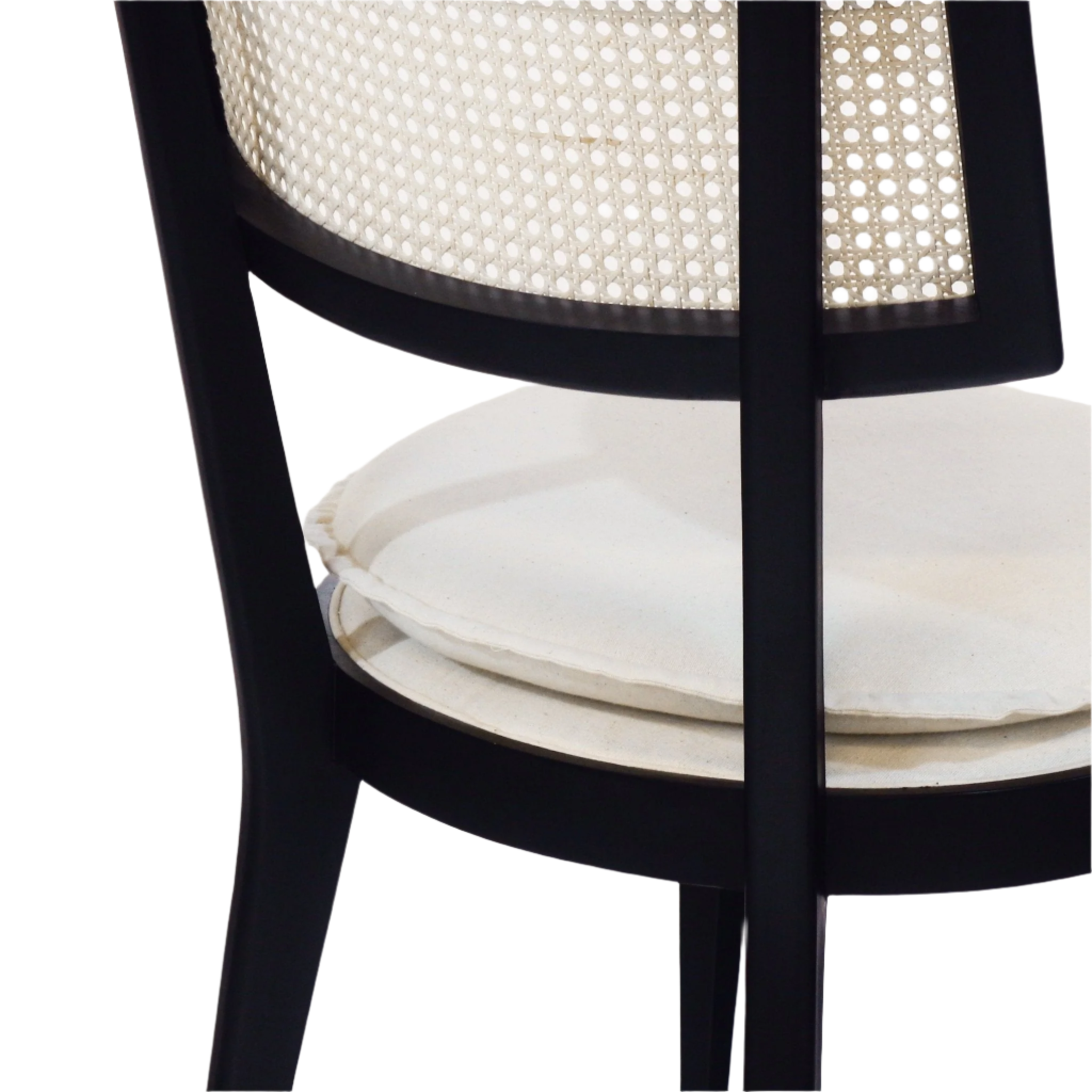Close-up of a black solid wood dining chair showing a woven natural cane backrest and a round cream upholstered seat cushion.
