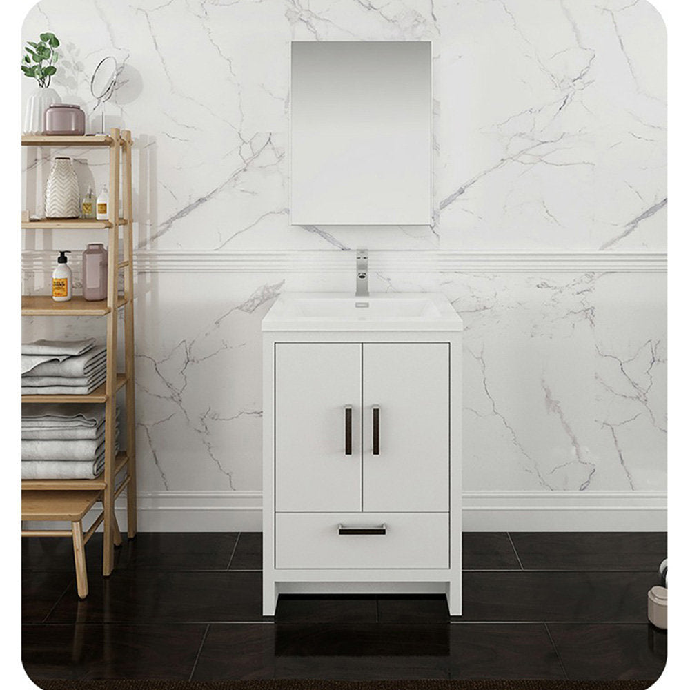 Freestanding solid wood 24-inch white single-sink bathroom vanity with stone top and integrated ceramic sink, dark metal hardware and under-sink drawer, shown with a rectangular mirror and wooden open shelving against a marble-look wall.