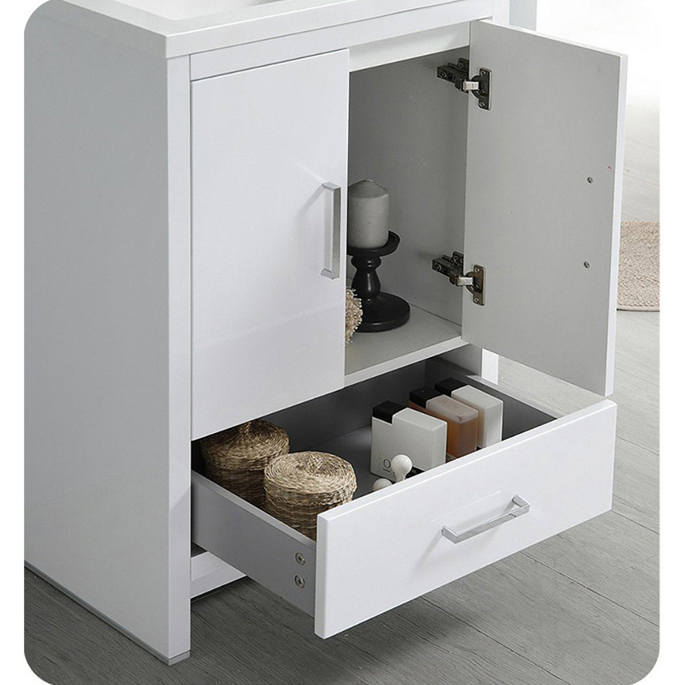 White solid-wood freestanding bathroom vanity with a stone top, one cabinet door open and a lower drawer pulled out showing wicker baskets, toiletries and a candle on a small black stand.