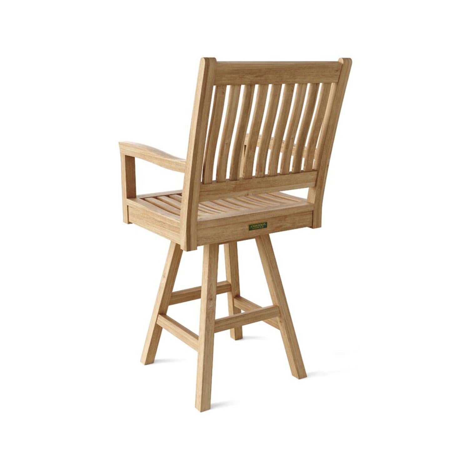 Rear three-quarter view of a natural teak outdoor swivel bar stool with slatted back and seat, integrated armrests, and a four-legged tapered base with a footrest in a coastal style.