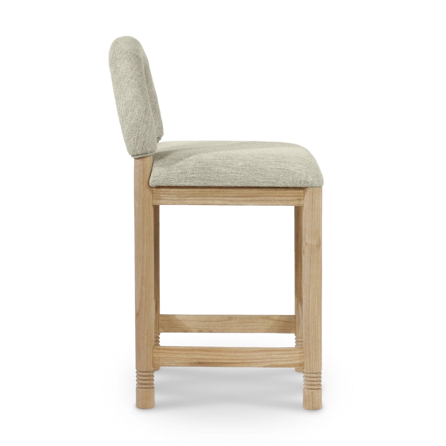 Side view of a counter stool with a natural oak frame and beige bouclé upholstered seat and rounded back, featuring horizontal foot rails and subtle turned details on the legs.