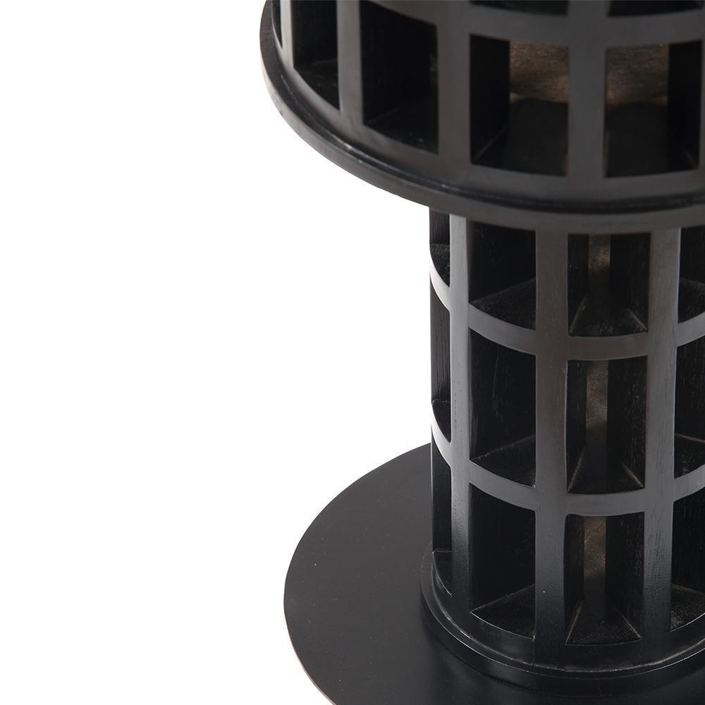 Close-up of a black mahogany side table showing the honeycomb-style solid wood pedestal and round base, highlighting the grid-like cutouts and smooth circular top edge in a modern contemporary finish.