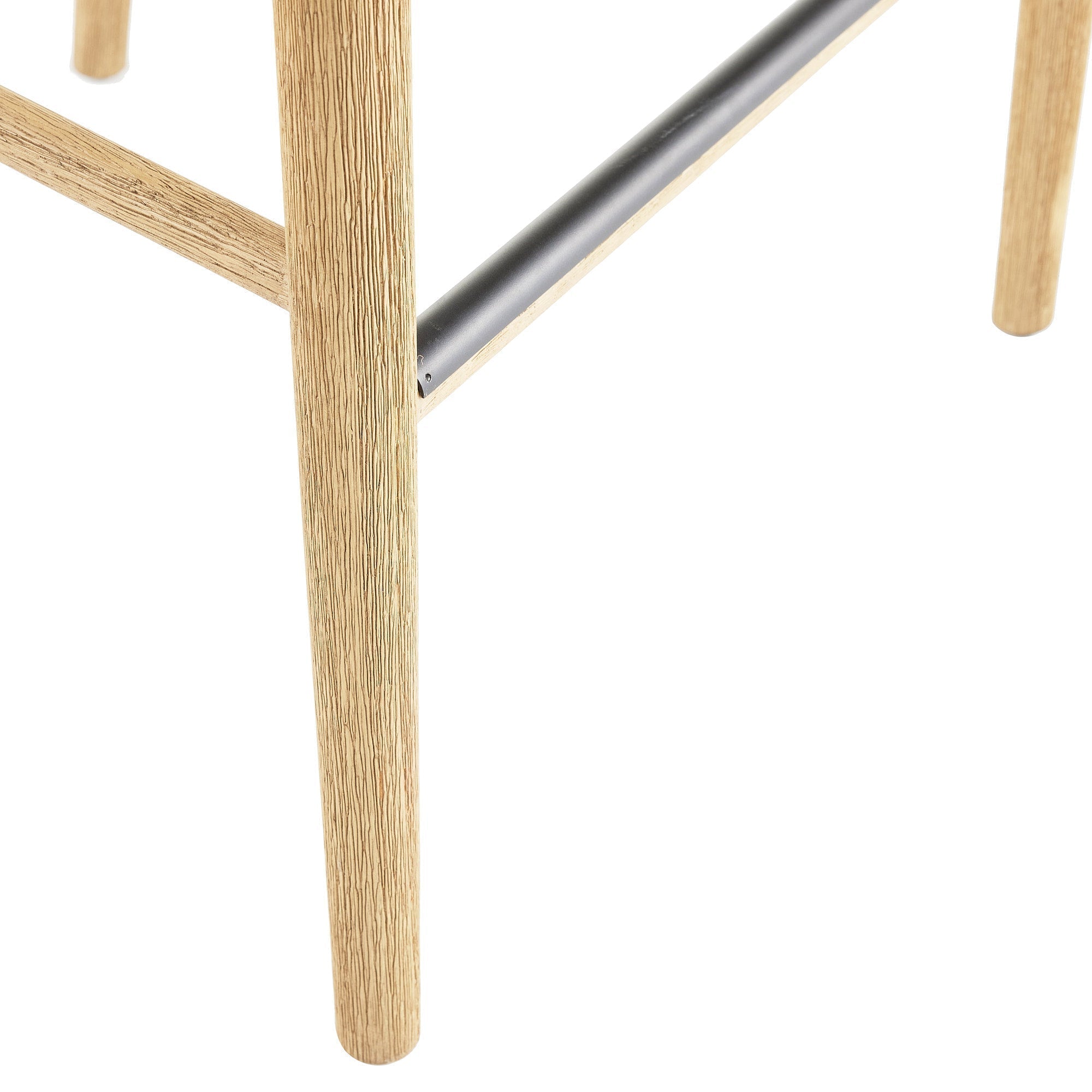 Close-up of a natural wood stool leg and cross support showing textured wood grain and a matte black metal footrest, highlighting the rounded leg profile and metal-to-wood connection.