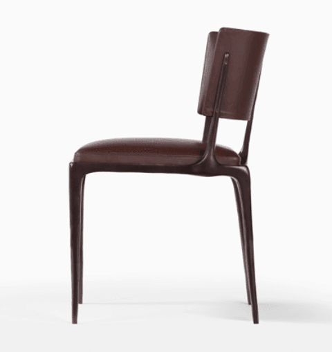 Side profile of a modern brown leather-look dining chair with a cushioned seat, curved backrest with visible seam detail, and slim tapered legs.