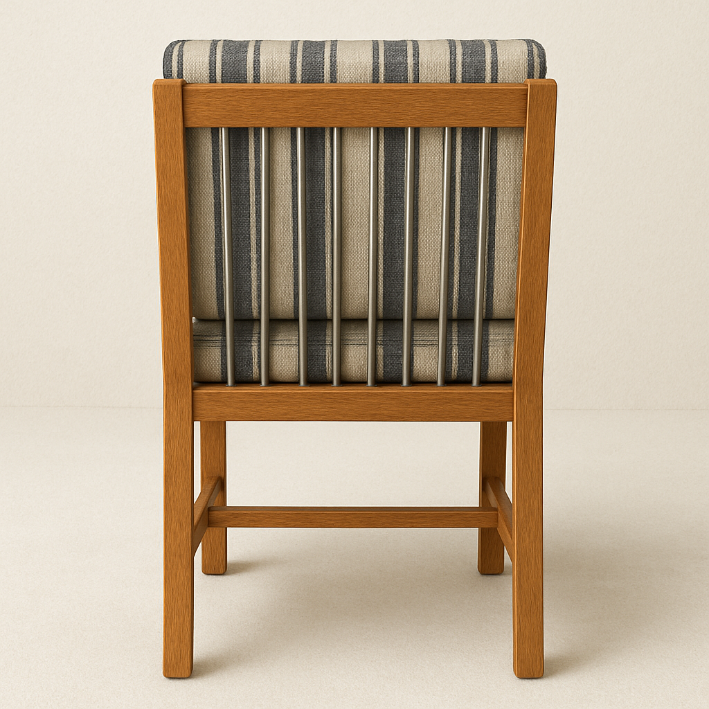 Rear view of an armless outdoor dining chair with a warm teak wood frame and vertical aluminum spindles, fitted with navy and beige striped fabric cushions.