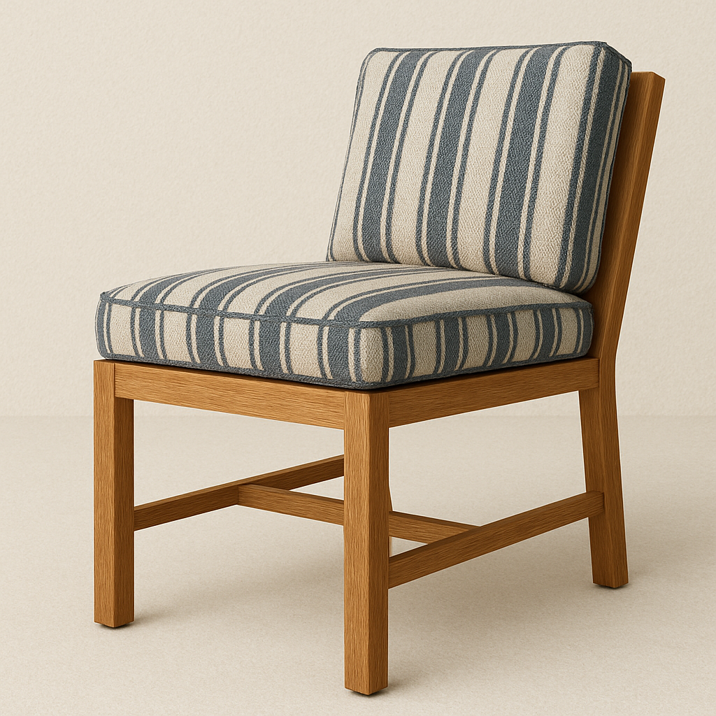 Armless outdoor dining chair with a warm teak wood frame and navy-and-beige striped fabric seat and back cushions, showing plush piped edges and cross-stretcher support in a coastal-contemporary style.