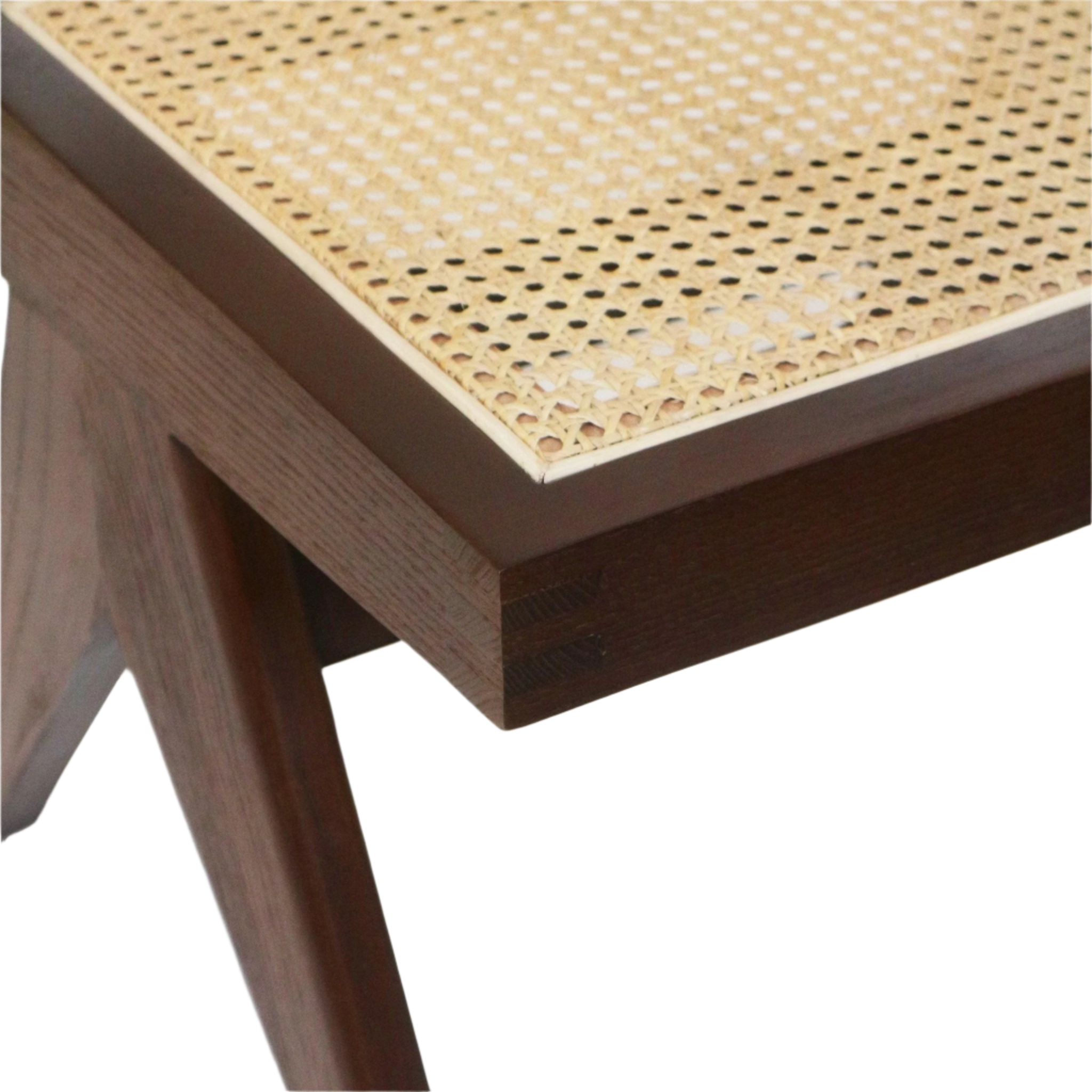 Close-up of an armless dining chair corner showing a natural cane woven seat inset in a walnut-brown solid wood frame with tapered leg and visible joinery.