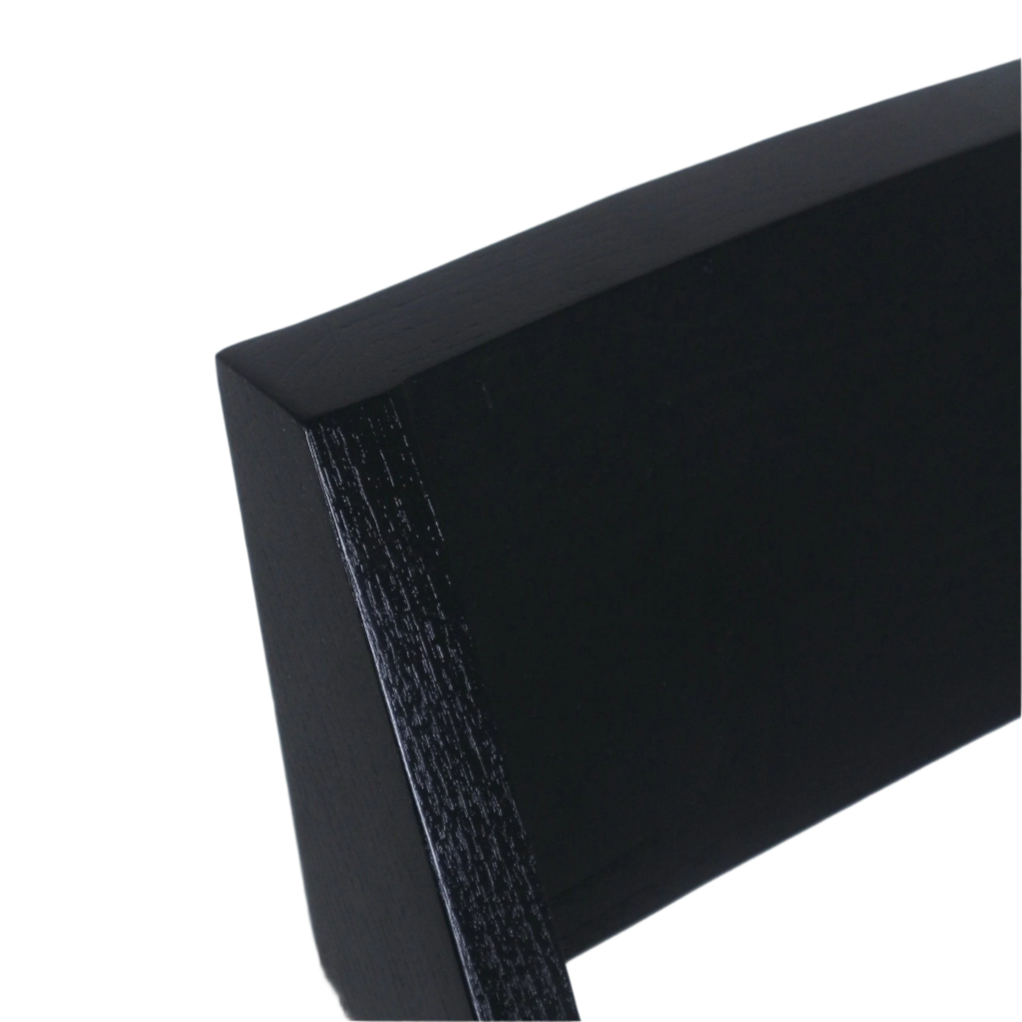 Close-up of a chair's black semi-gloss wood back edge showing textured wood grain and a squared profile against a white background.