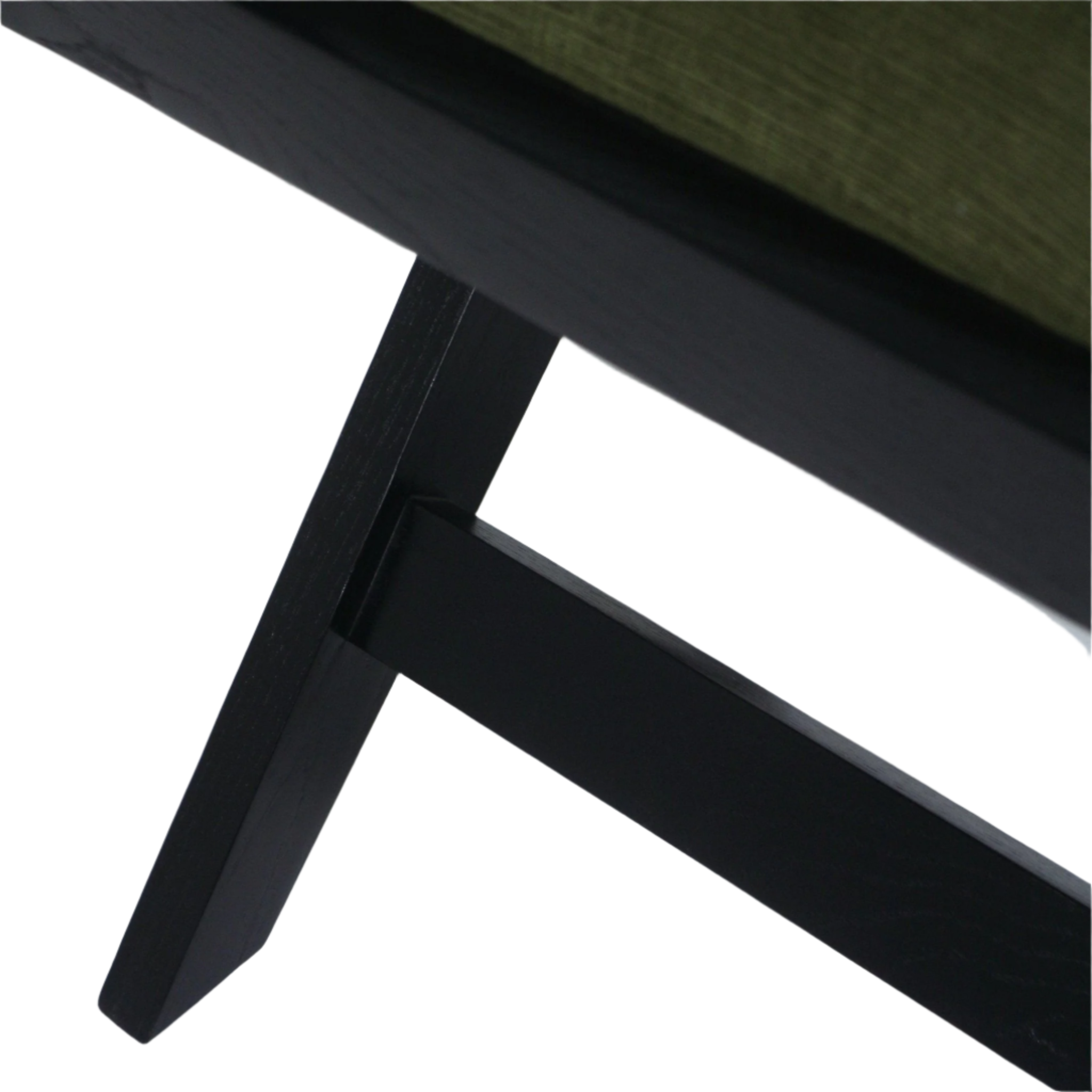 Close-up of a black semi-gloss wood side chair leg and horizontal stretcher with the green chenille upholstered seat edge visible at the top.