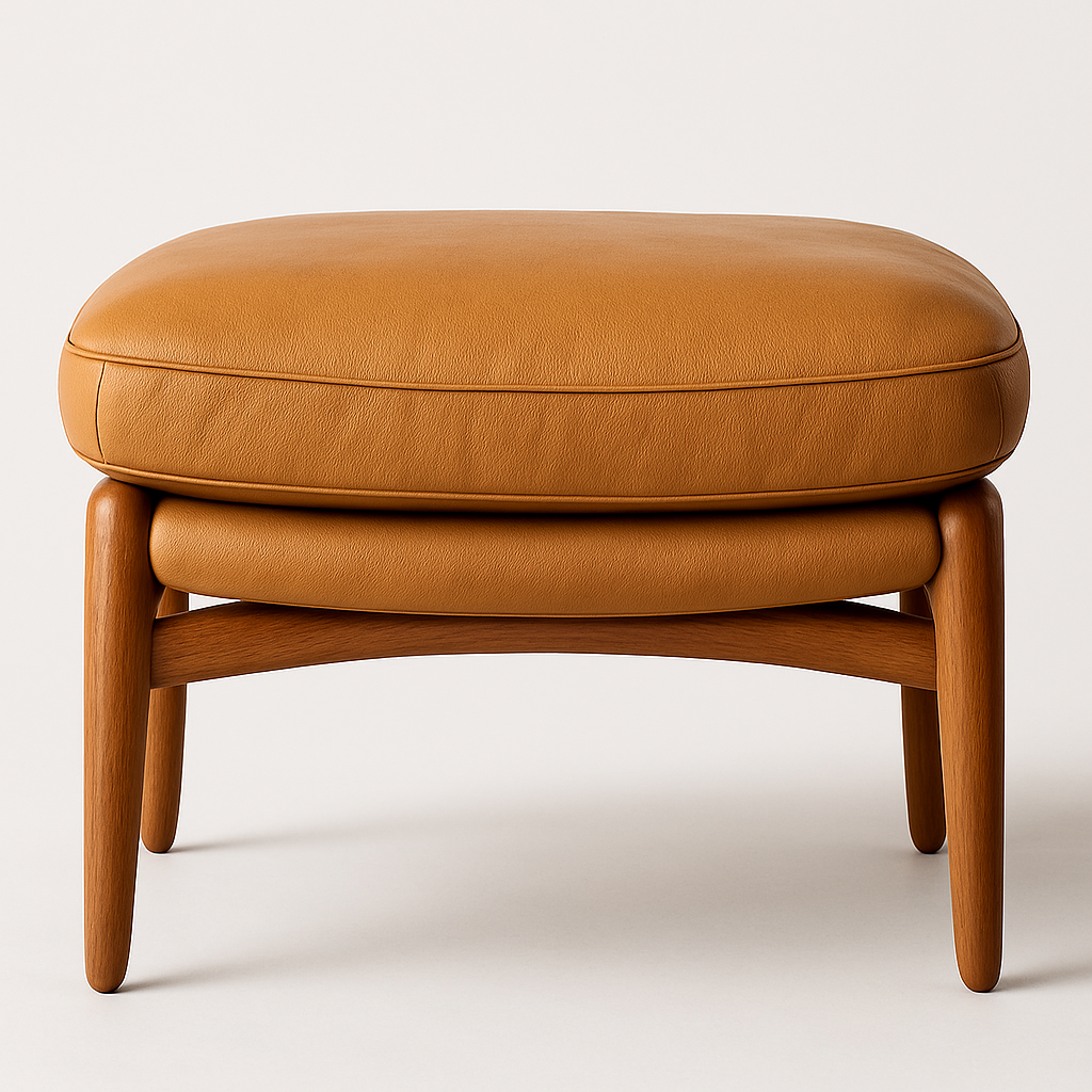 Front view of a tan leather ottoman with a rounded cushioned top, stitched piping detail and solid wood tapered legs in a warm brown finish against a neutral background.