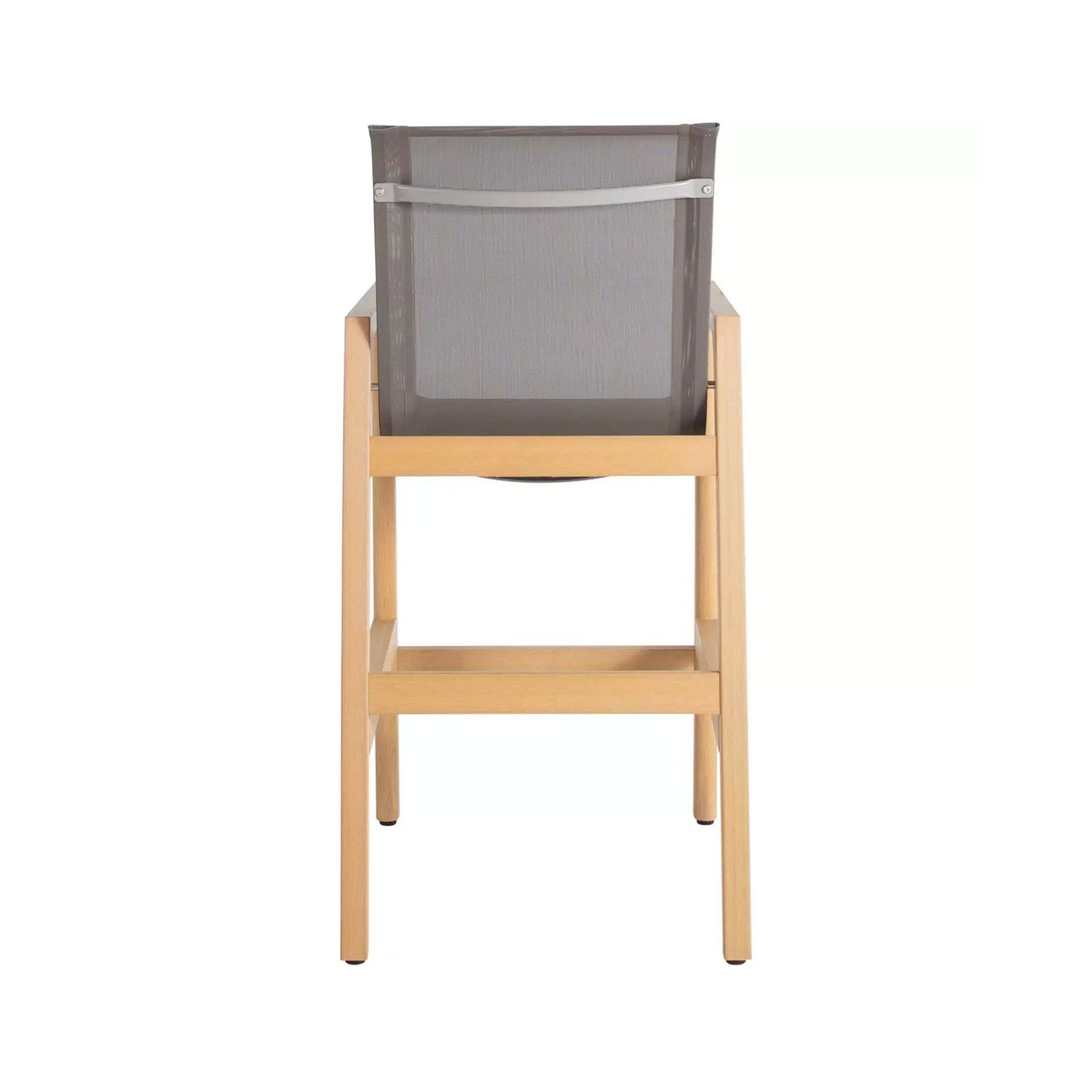 Back view of a teak outdoor bar stool with a natural wood frame, gray mesh sling back supported by a horizontal metal bar, and a built-in footrest.