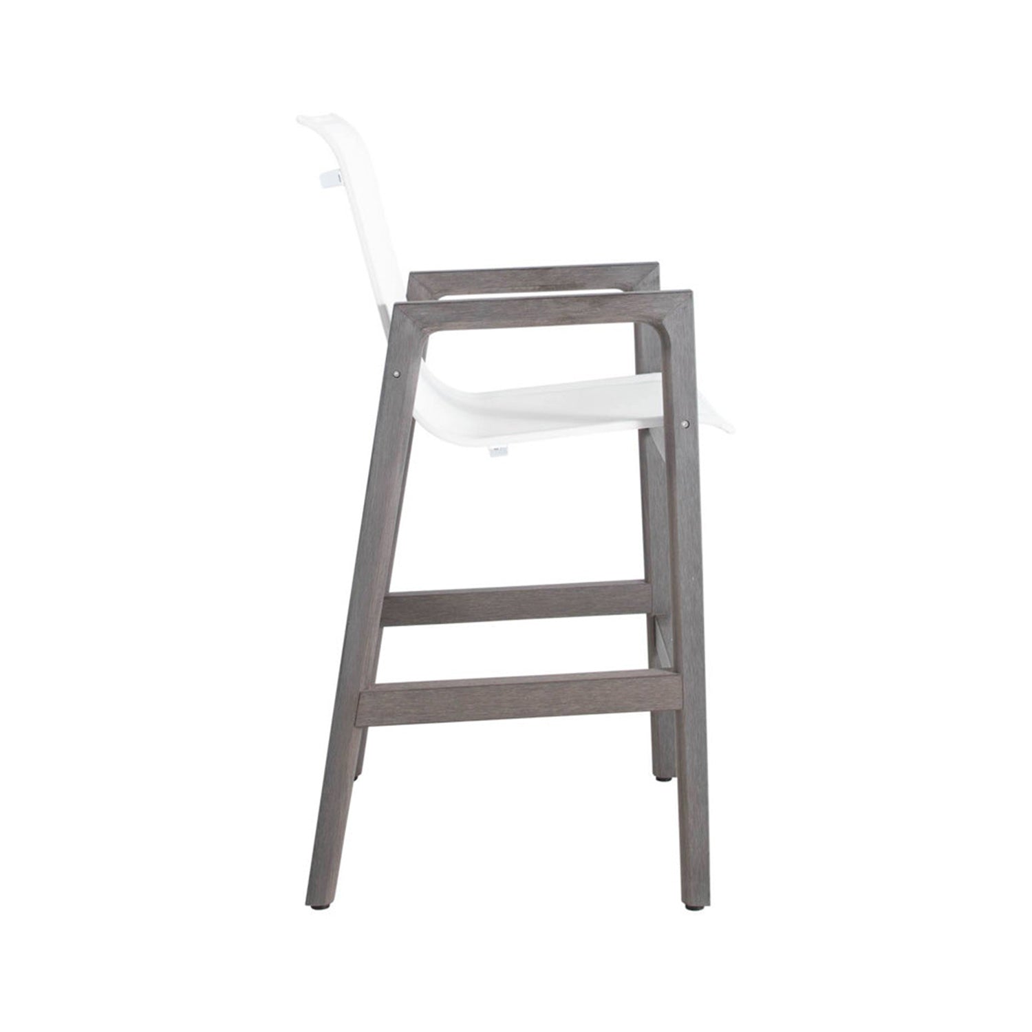 Side view of a coastal outdoor bar stool with a weathered teak wooden frame, white molded seat and low back, integrated armrests and a built-in footrest.