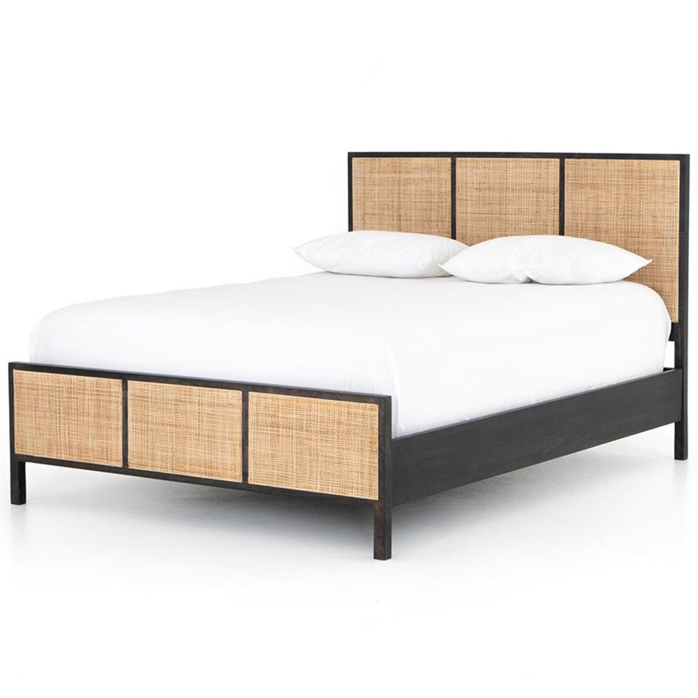 Teak platform bed with woven rattan cane panels on the headboard and footboard, dark wooden frame, dressed in white bedding with two pillows for a relaxed boho bedroom look.