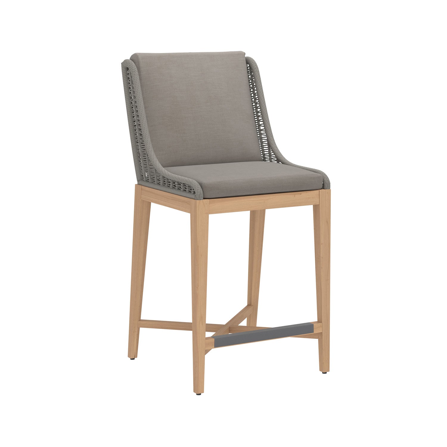 Armless outdoor bar stool with cushioned grey fabric seat and back, woven grey rope side detailing, solid teak wood frame and legs, and a dark metal footrest for coastal-style counter seating.