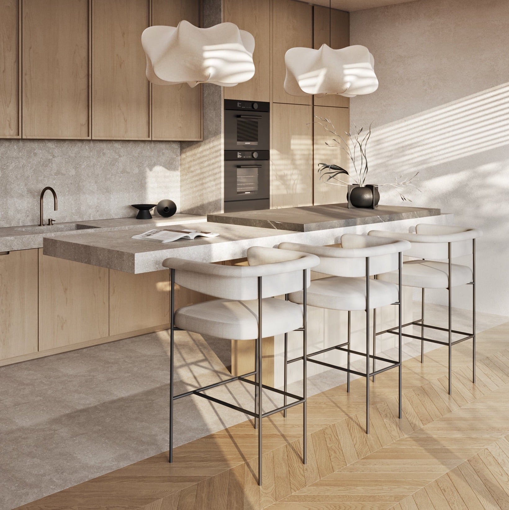 Three cream faux-leather counter-height stools with curved backs and slim dark metal frames tucked at a stone-topped kitchen island in a modern neutral kitchen with light wood cabinets and sculptural pendants.