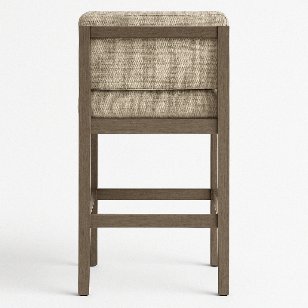 Rear view of an armless teak outdoor bar stool with beige upholstered fabric back and cushioned seat, rectangular teak frame and two horizontal footrest rails.
