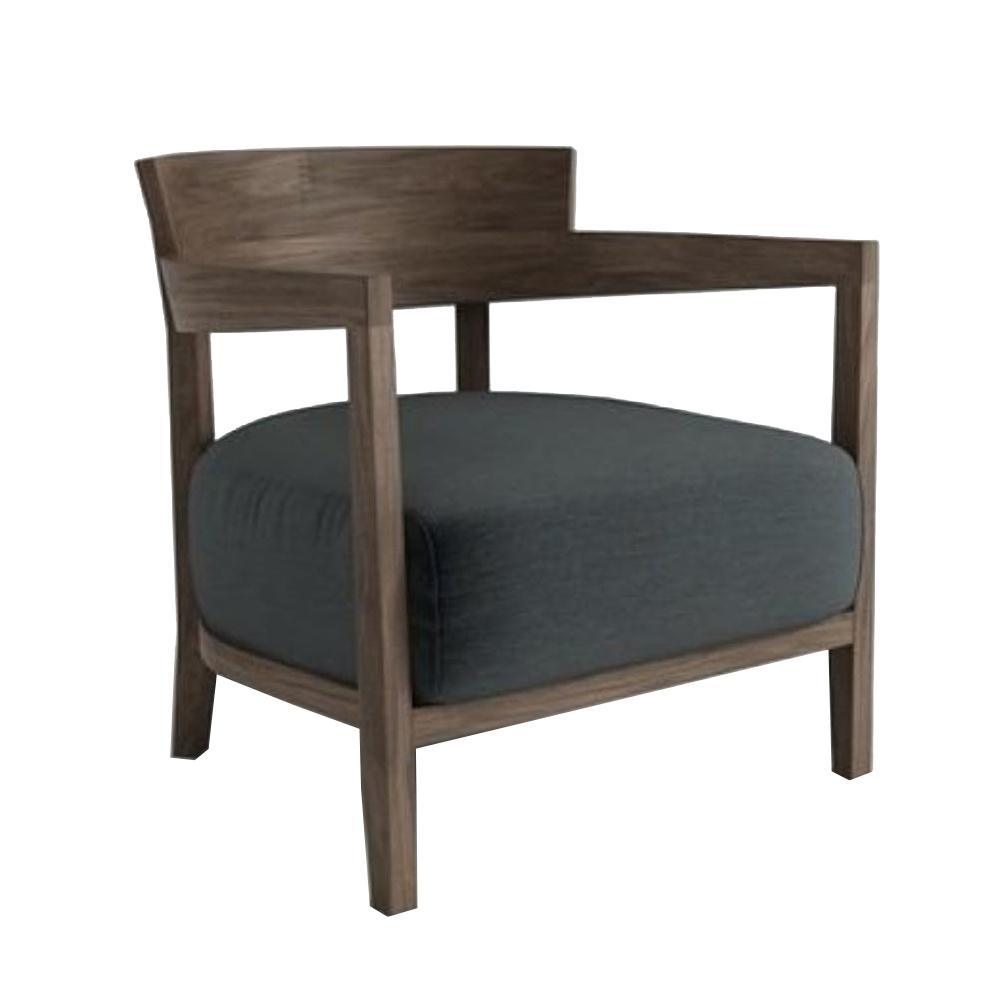 Modern lounge chair with solid teak frame and dark gray fabric upholstery, featuring open wooden arms, a low curved back, and a thick cushioned seat.