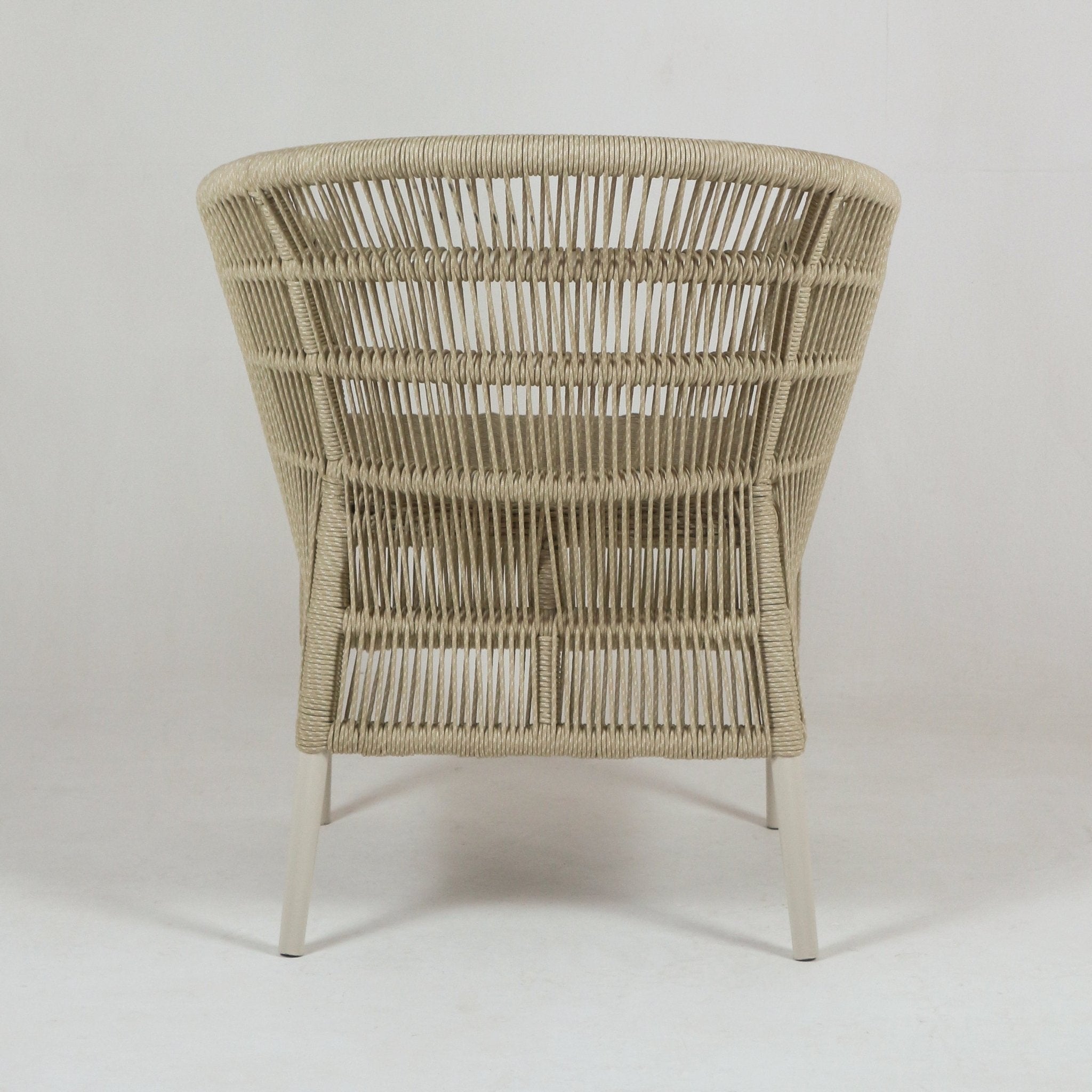 Rear view of a coastal patio chair showing a beige woven rope back and cream metal legs with an open, airy weave.
