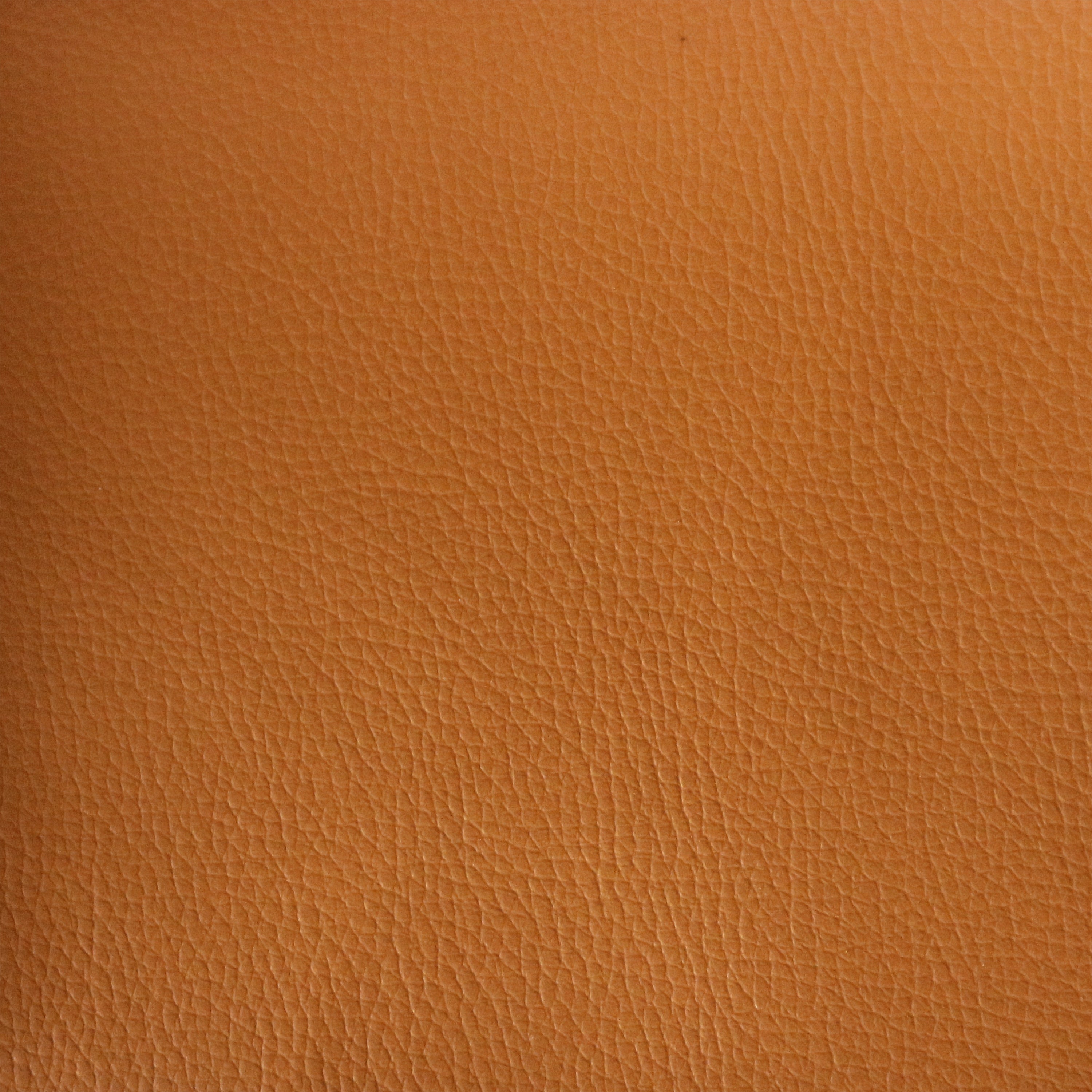 Close-up of tan leather upholstery showing fine pebble-grain texture and subtle natural creases, warm brown-tan color used for mid-century modern dining chair seats.