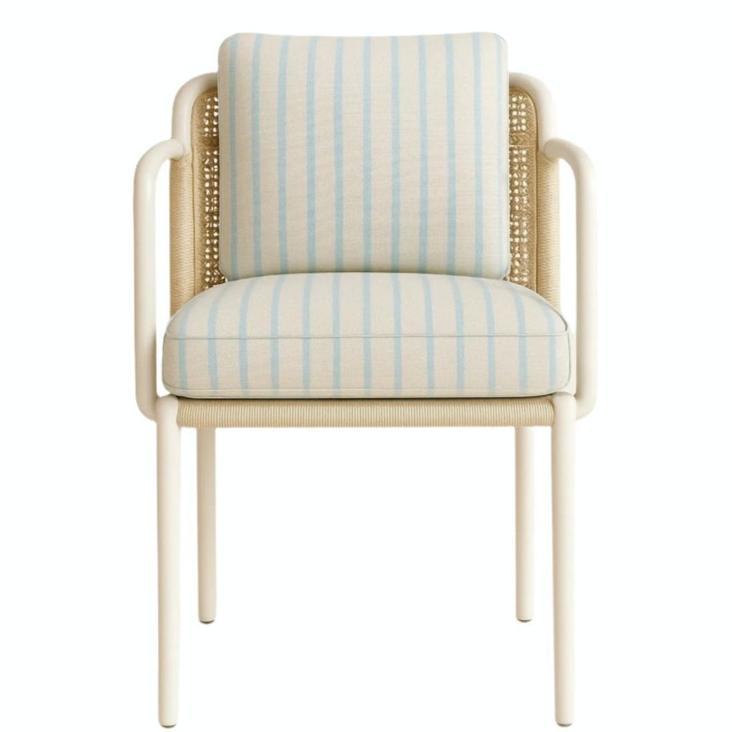 Front view of a coastal dining chair with a white aluminum frame, woven cane side panels and a cream fabric seat and back covered in pale blue vertical stripes.
