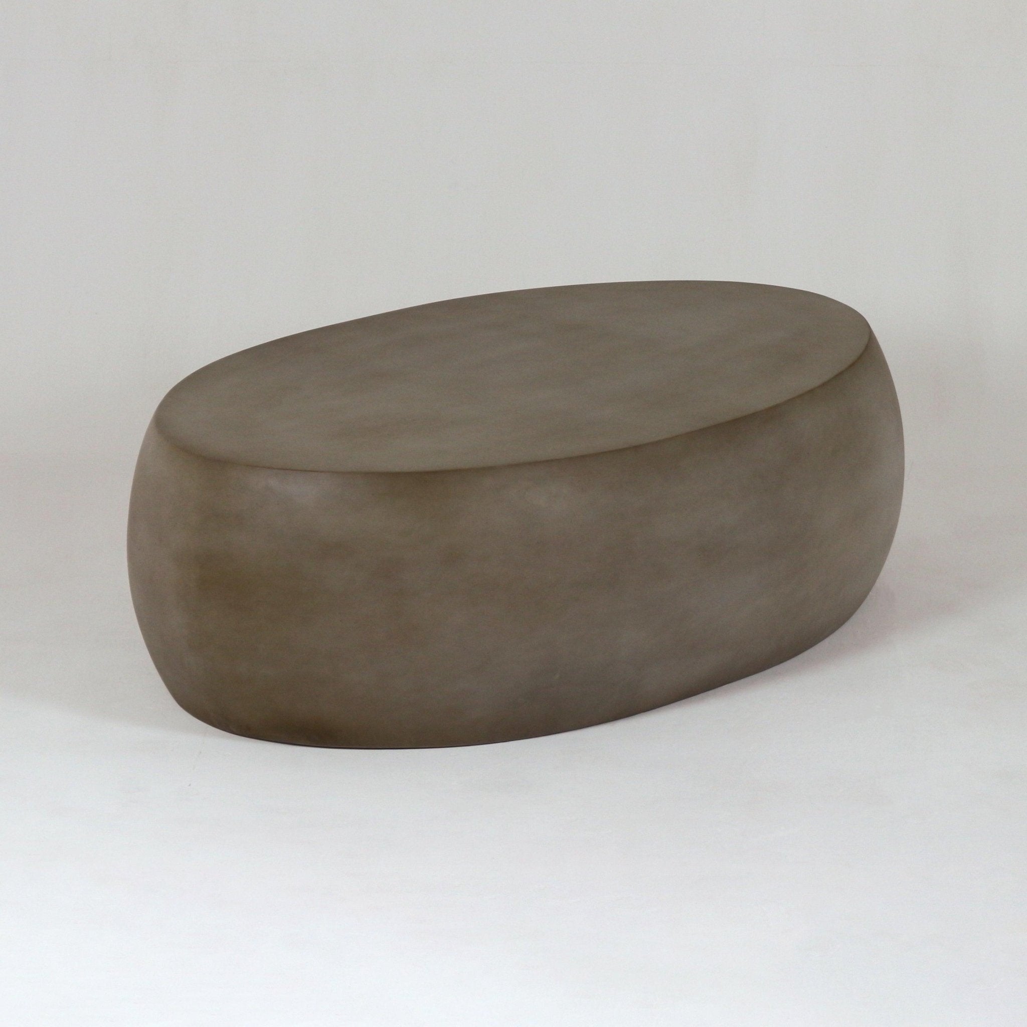 Low pebble-shaped modern outdoor coffee table in mahogany-toned fiber concrete with smooth rounded edges and a matte finish, shown on a plain neutral background.