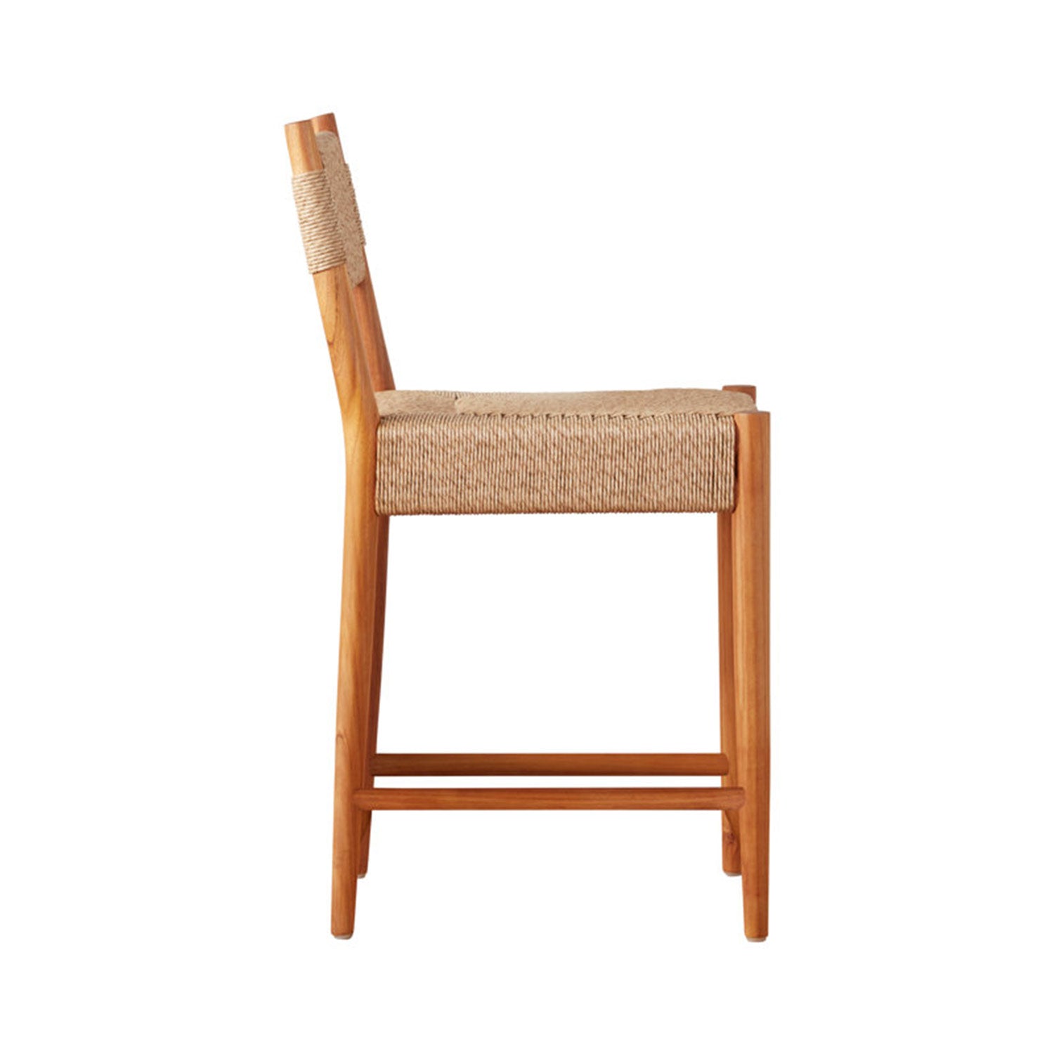 Side profile of an armless teak counter stool with a natural woven fiber seat, short rope-wrapped back detail and teak frame with footrest, shown on a white background.