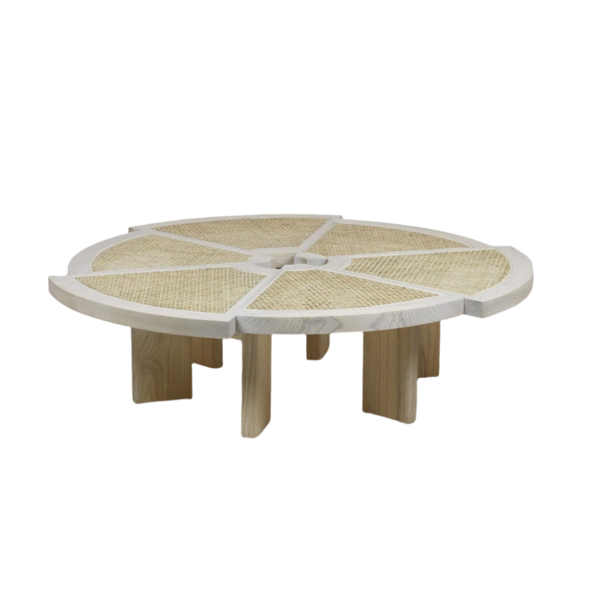 Low round coffee table in light natural solid wood with segmented cane rattan insets radiating from a small center opening, supported by thick interlocking wooden legs in a modern minimalist style.