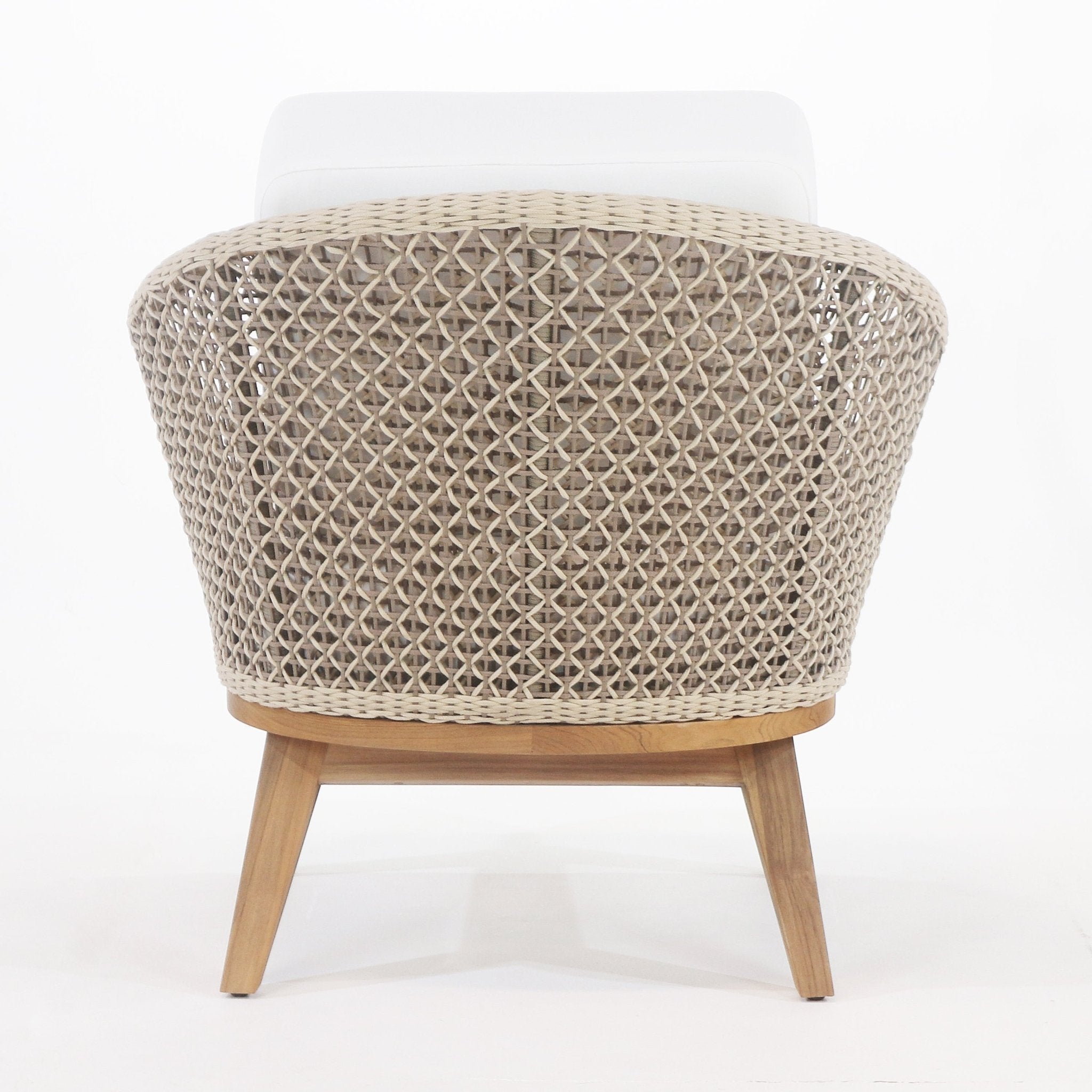 Rear view of a coastal outdoor accent chair with a beige rope-woven back, white fabric cushion visible at the top, and angled teak legs and base.