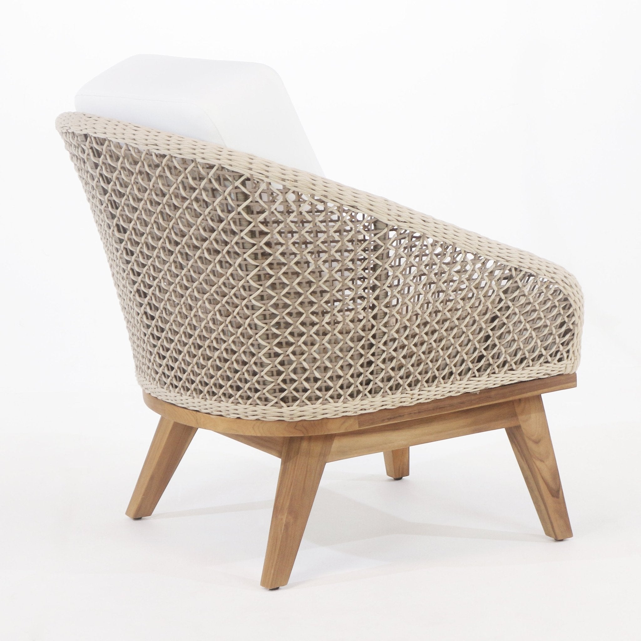 Rear-side view of a coastal-style outdoor accent chair with a beige woven rope back, teak wood base and angled legs, and a white fabric cushion.