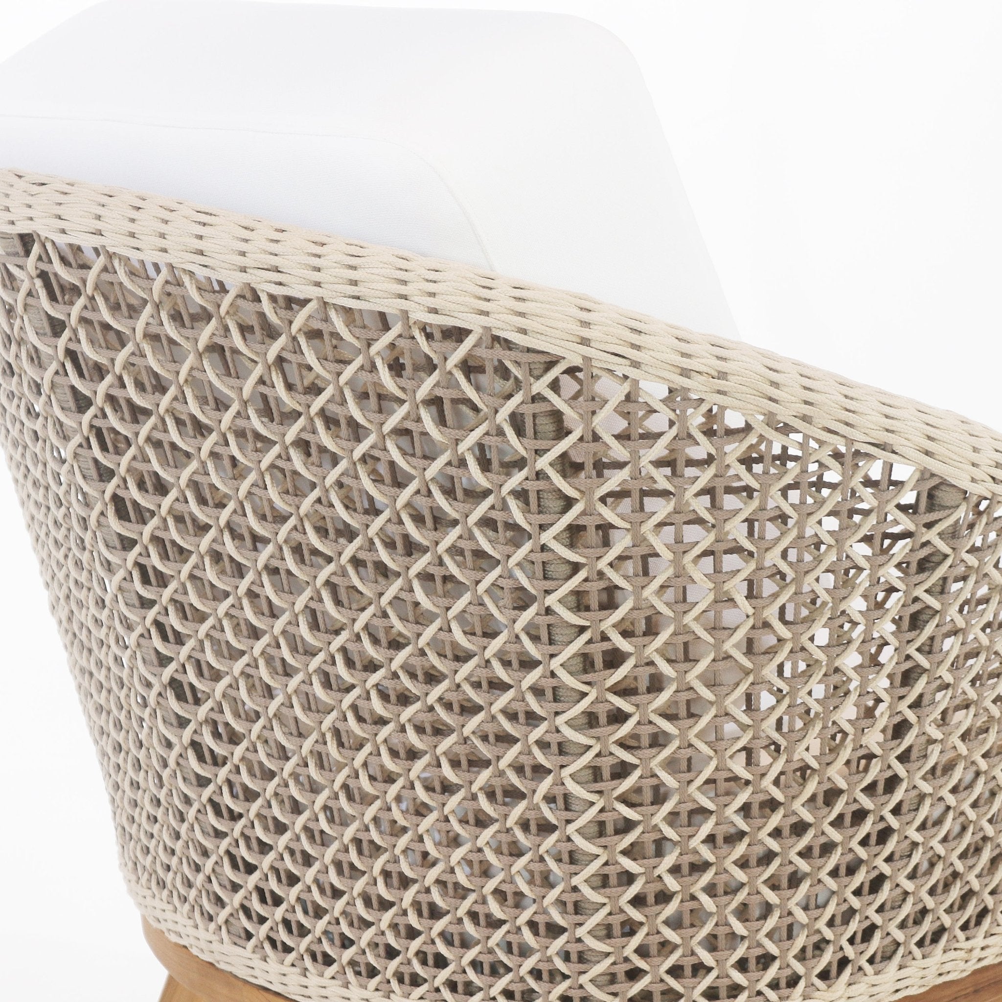 Close-up of an outdoor accent chair showing a beige rope-woven open-lattice back, a white fabric seat cushion peeking over the top, and the edge of a natural wood base.