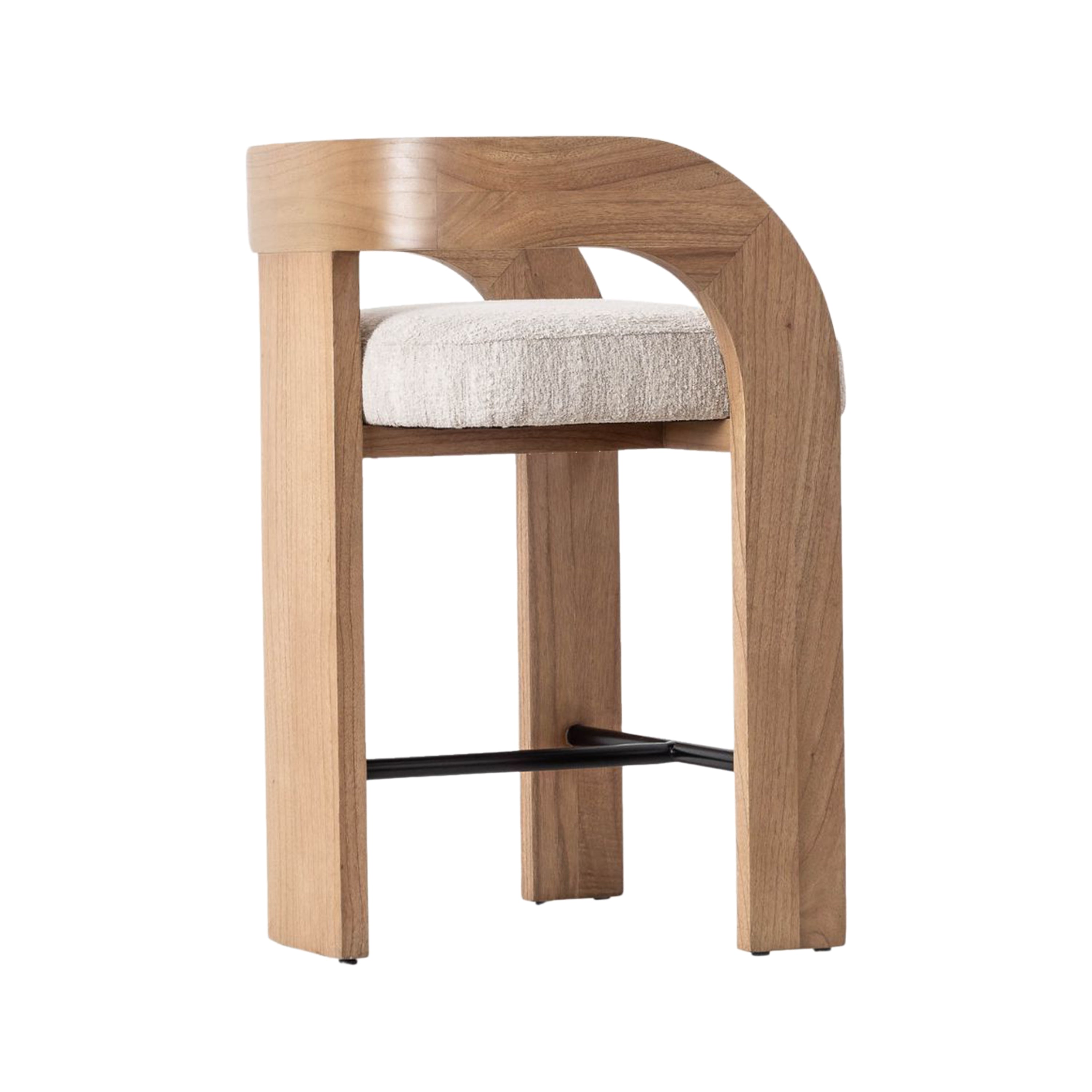 Side view of a counter-height stool with a curved U-shaped natural wood back and armrest, cream fabric upholstered seat, straight wood legs and a black metal footrest in a modern Scandinavian style.