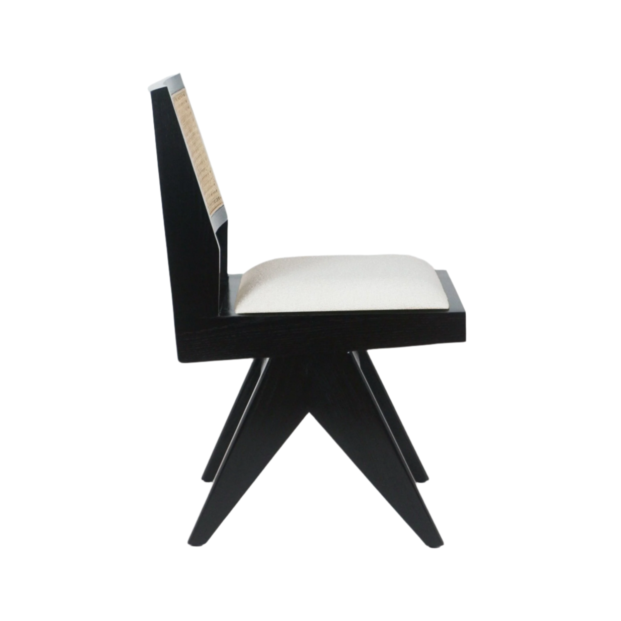 Side profile of a mid-century modern armless dining chair with a black solid ash frame, natural cane back inset and cream upholstered seat cushion on an angular star-shaped leg base against a white background.