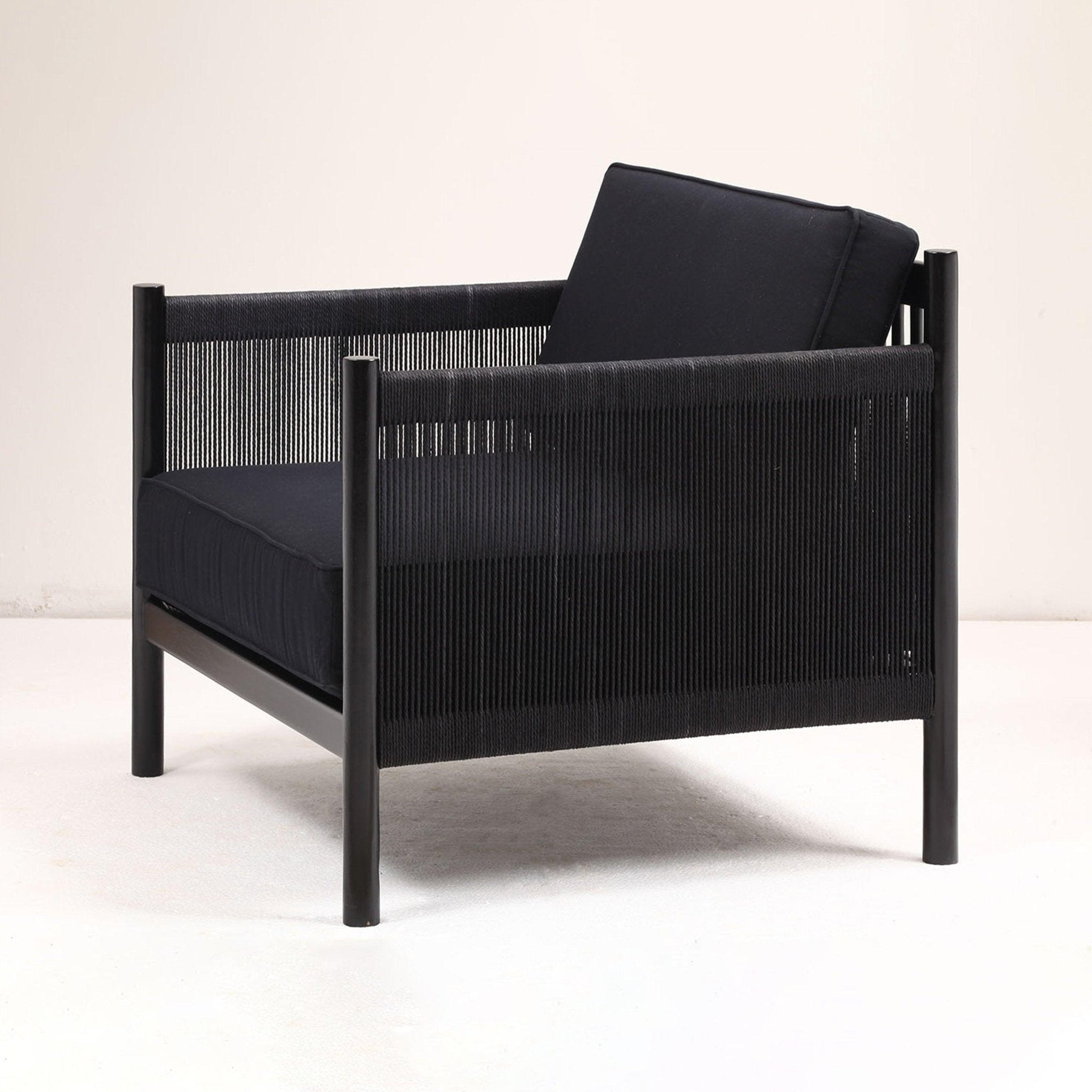 Modern black lounge chair with a solid wood frame, woven black rope sides and cushioned black fabric seat and back, shown angled three-quarter on a neutral background.