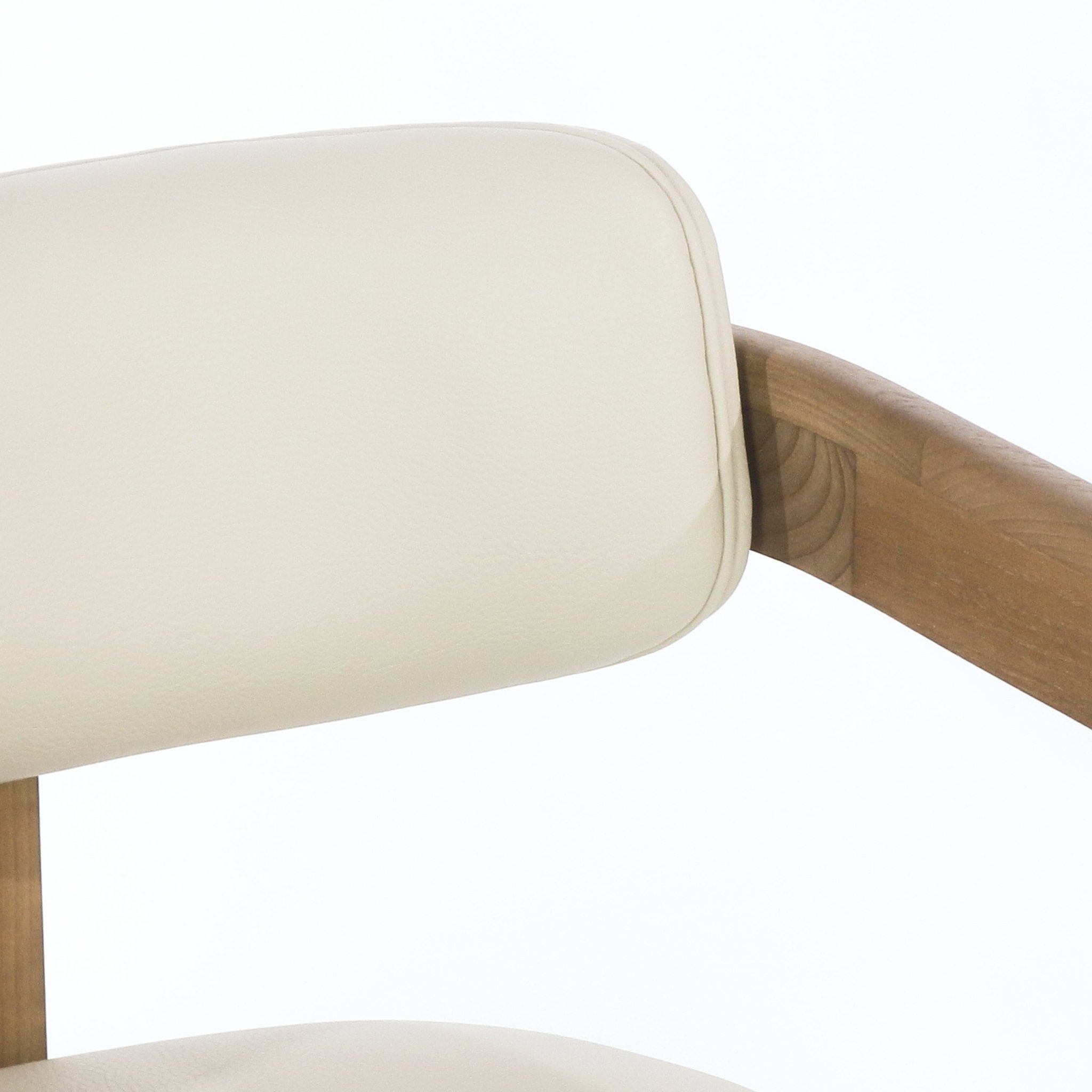 Close-up of a padded beige leather backrest and curved teak wood arm of a mid-century modern dining chair, showing stitched piping and natural wood grain.
