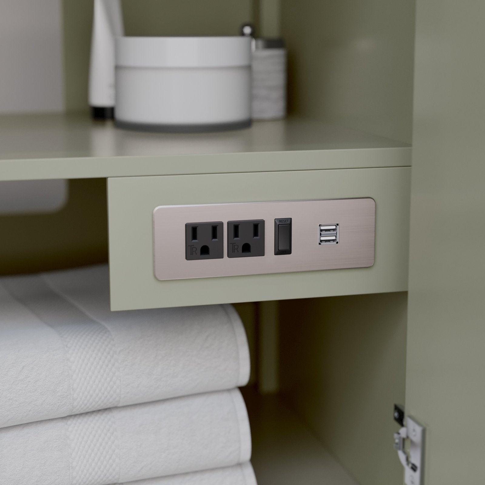 Close-up of a stone-colored solid wood bathroom vanity interior showing a brushed-nickel recessed power plate with two grounded outlets, a reset switch and dual USB ports above neatly folded white towels.