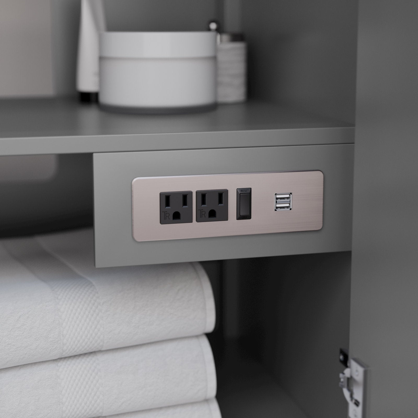 Close-up of the inside of a stone-finish solid wood modern vanity showing a brushed-nickel outlet panel with two grounded sockets, a GFCI reset switch and two USB ports above folded white towels.